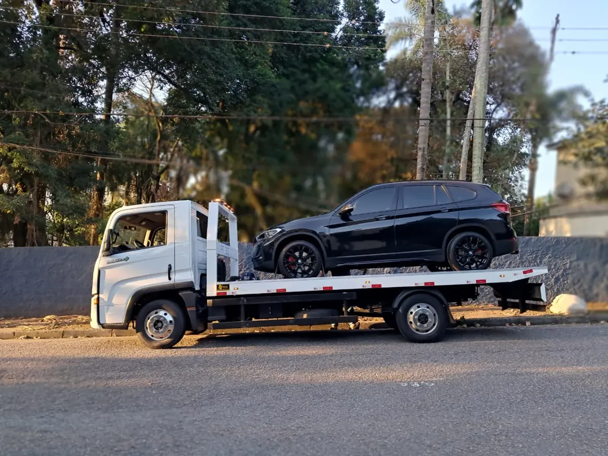 Guincho plataforma transportando um veículo utilitário